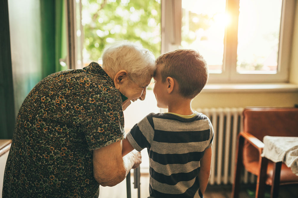 Charter Senior Living Columbia resident standing in doorway with young grandson