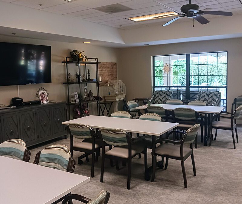 community room with large window, television and seating
