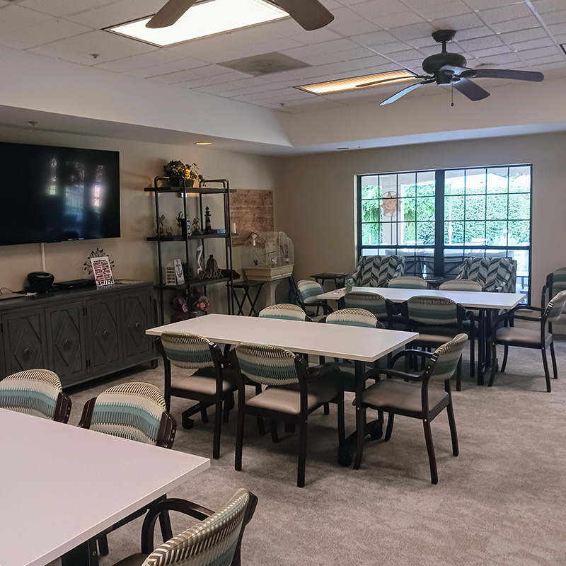 community room with large window, television and seating