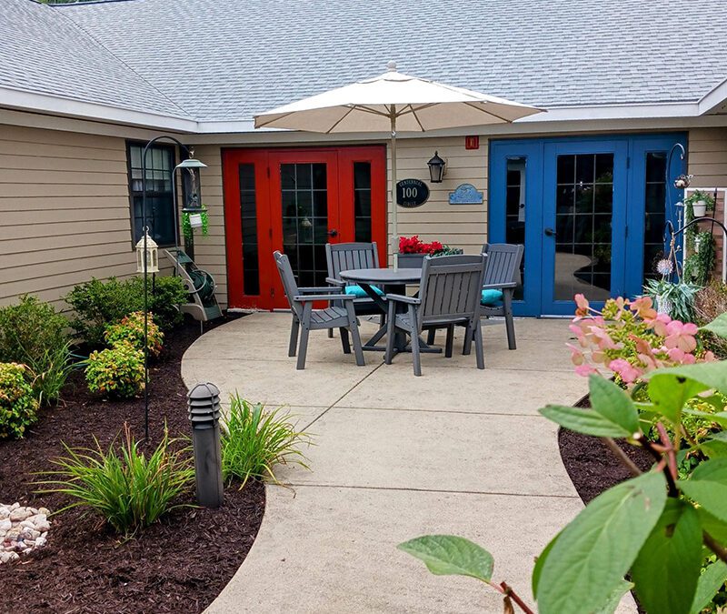 outdoor patio surrounded by flowers and bushes
