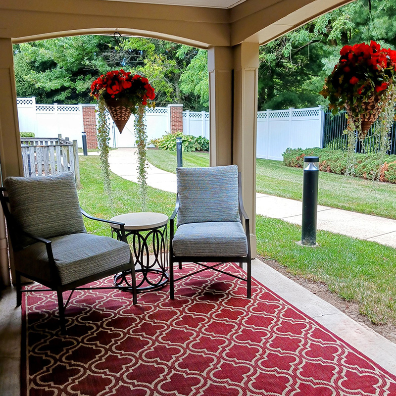 shaded porch with rug, seating and plants